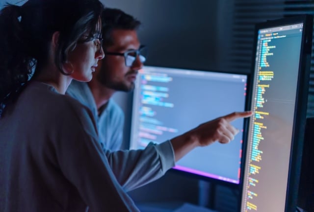 Computer, Female Programmer And Male Training For Coding, Cyber Security Or Software On Computer. Female It Specialist, Male Coder Or Talking To Connect Internet, Information Update And Cloud Computing . Coding Development Concept.